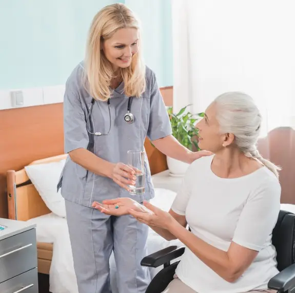 Enfermera dando medicamentos al residente